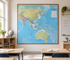 A framed world map of Asia and Australia hanging on a classroom wall, surrounded by desks, chairs, books, a globe, and a whiteboard.